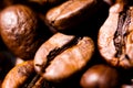 Macro close up of pile of roasted brown coffee beans in natural sunlight showing details of surface