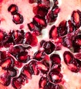 A macro close up of a pomegranate fruit sliced into.