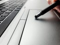 macro close-up of someone using a stylus pen on computer laptop technology background Royalty Free Stock Photo