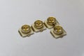 Close-up of symmetric aligned gold plated uFL micro precision radio connector in partial focus white background