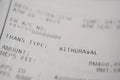 Macro closeup of a auto teller machine bank slip. selective focus on WITHDRAWAL word Royalty Free Stock Photo