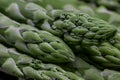 Macro closeup of green asparagus with focus on asparagus heads with parts of stem visible