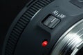 Macro closeup photo of lens to dslr camera on dark background view of red dot and silver extension ring and autofocus button Royalty Free Stock Photo