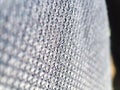 Macro closeup showcasing the intricate detail of grey fabric textile.