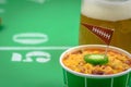 Closeup of a small bowl of chili and beer mug on table decorated