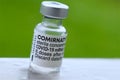 Macro of Comirnaty Biontech vaccination ampoule against Covid-19 or Corona virus with green background Royalty Free Stock Photo