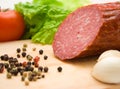 Macro of cut salami, pepper seeds and vegetables Royalty Free Stock Photo