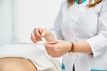 Macro detail of female hand using an insertion tube to insert a Goshin acupuncture needle in the back of a female Royalty Free Stock Photo