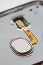 Macro detail of fingerprint scanner on smartphone with exposed electronic contacts