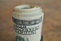 Macro detail of a green roll of American currency USD, American dollars with 100 dollars bank note on the outside as a symbol of