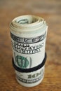 Macro detail of a green roll of American currency USD, American dollars with 100 dollars bank note on the outside as a symbol of