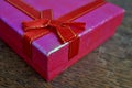 Macro detail of a red ribbon with golden stitching wrapping a pink christmas present Royalty Free Stock Photo
