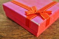 Macro detail of a red ribbon with golden stitching wrapping a pink christmas present Royalty Free Stock Photo