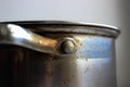 Macro detail of a stainless-steel pot with stained surface and riveted handle. Realistic kitchen cookware texture for cleaning Royalty Free Stock Photo