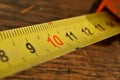 Macro detail of yellow metal tape meter with red and black numbers