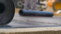 MACRO Detailed shot of a bitumen roll as worker burns a layer of hydroinsulation Royalty Free Stock Photo