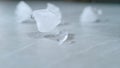 MACRO, DOF: Melting pieces of ice get scattered across the empty dining table. Royalty Free Stock Photo