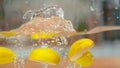 MACRO, DOF: Slices of a ripe yellow apple fall into the water and make a splash Royalty Free Stock Photo