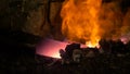 MACRO: Person forging a blade pulls a piece of metal out of the burning ember.