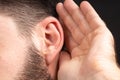 Macro ear of man with palm eavesdropping on secret information or secrets. Concept of foreign spy or foreign Royalty Free Stock Photo