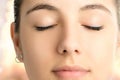 Macro face shot of woman meditating with eyes closed.