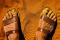 Macro of feet with sandals soiled with ocher and yellow sand in the roussillon ocher quarry Royalty Free Stock Photo