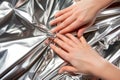 macro of fingers smoothing out a crease in shiny metallic gift wrap