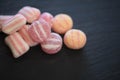 Macro food photography of sugar candy sweets in red pink and white stripe patterns on dark slate background Royalty Free Stock Photo