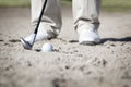 Macro of golfer in bunker.