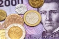 A close up image of assorted Chilean coins on a two thousand peso note