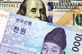 A blue South Korean one thousand won note with an American one hundred dollar bill