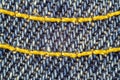 Macro image of blue jeans interwoven gold thread, denim texture background. Royalty Free Stock Photo