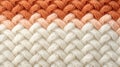 Macro image of a close-up texture of a knitted pattern, white, cream and orange colors filling the frame