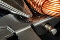 Macro Image of a coil of copper wire and a pair of needle-nose pliers with a carpenter`s caliper