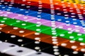 A Macro image of Diagonal rows of multicolored dice, lined in OCD fashion using the numbers to form perpendicular symmetry.