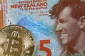 Close up image of a New Zealand five dollar bill with a bitcoin