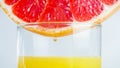 Macro image of fresh grapefruit slice in glass of juice