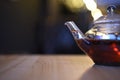 Drink photography image of a close up glass teapot filled with hot red color apple spice fruit tea with bokeh background Royalty Free Stock Photo