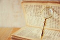 Macro image of magnifying glass over antique open book. Royalty Free Stock Photo