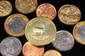 An assortment of Brazilian coins on a black reflective background with a South African one ounce gold Krugerrand coin Royalty Free Stock Photo