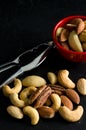 Macro Image of Mixed Nuts, Nutcracker Tool and Red Bowl Royalty Free Stock Photo