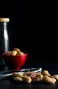 Macro Image of Mixed Nuts with Red Bowl Nutcracker Tool and Glass Bottle Royalty Free Stock Photo