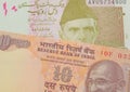 A orange ten rupee bill from India paired with a pink and grey ten rupee note from Pakistan.