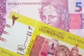 A pink and purple five real bank note from Brazil paired with a green two pound bank note from Sudan.