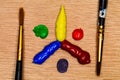 A macro image of a Primary and Secondary Color Wheel made of blobs of acrylic paint with two Artist`s brushes ready to use, all o Royalty Free Stock Photo