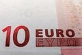 A macro image of the red microprint on a 10 Euro banknote, emphasizing the advanced tamper-proof technology used to