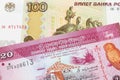 A Russian one hundred ruble note paired with a pink and white twenty rupee bank note from Sri Lanka.