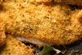 Macro image of seasoned cornmeal breading on a fried catfish fillet, revealing the various herbs and spices used