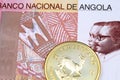 A one hundred Angolan kwanza bank note with a gold South African krugerrand coin Royalty Free Stock Photo