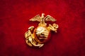 Macro image of the US Marine Corps emblem on red velvet as background and a grungy aesthetic. Semper fidelis or Semper Fi is Latin